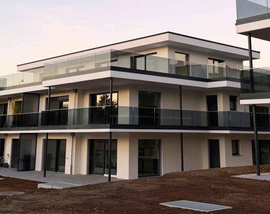 Neubau mit Glasbalkonen in der Abenddämmerung